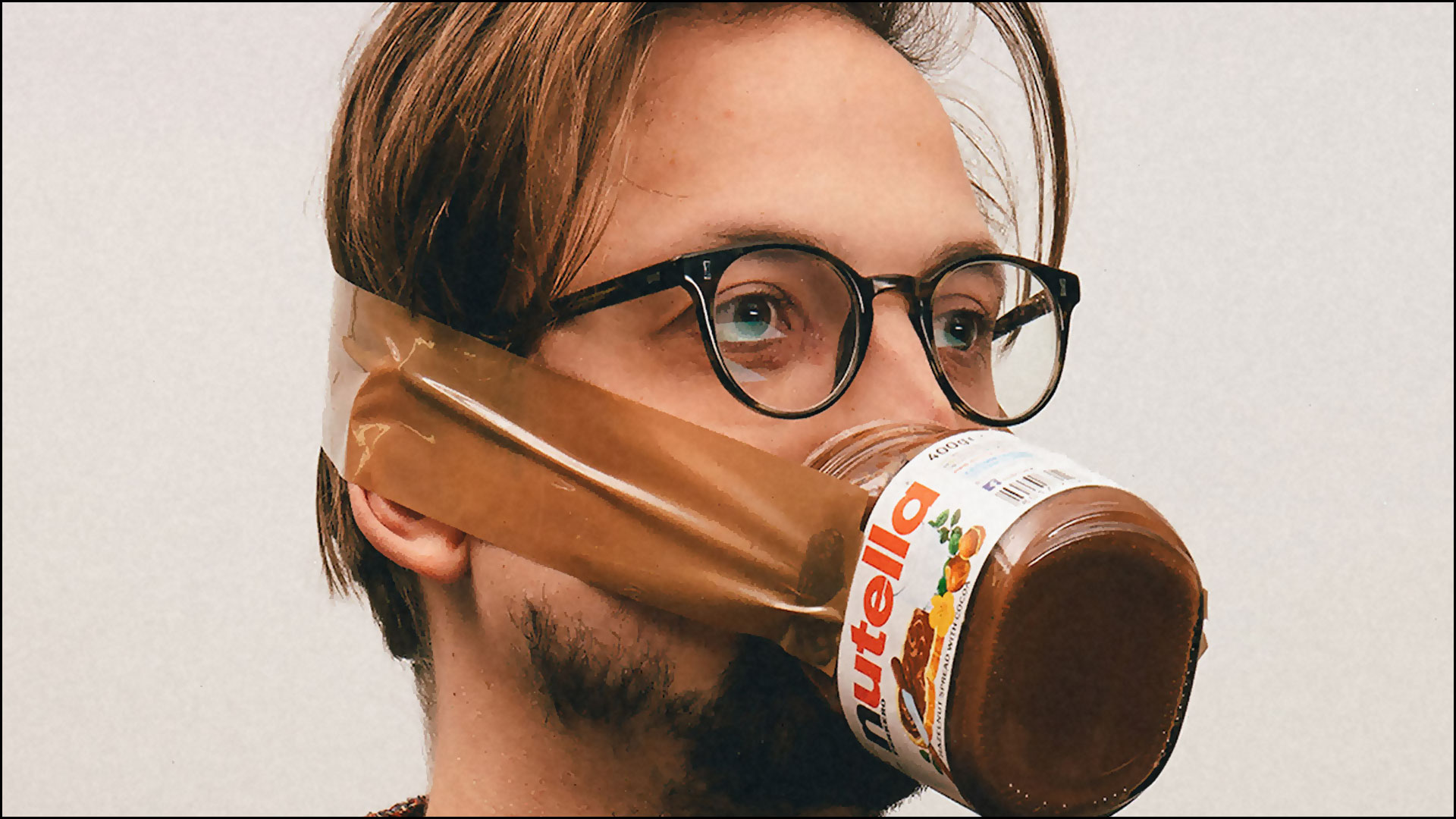 man wearing a jar of nutella as face mask